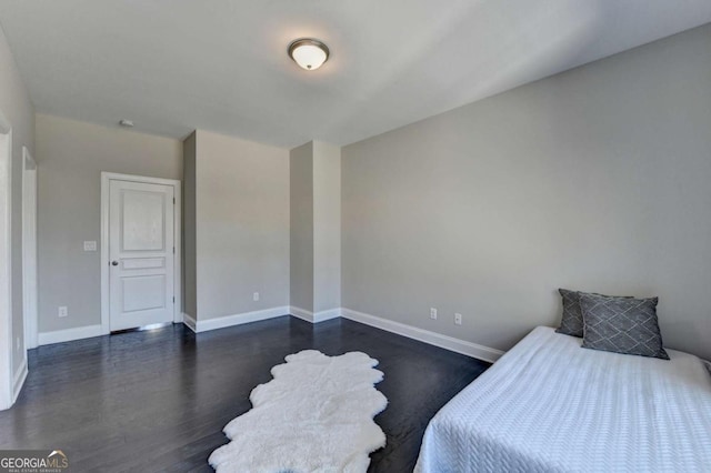 bedroom with dark hardwood / wood-style floors