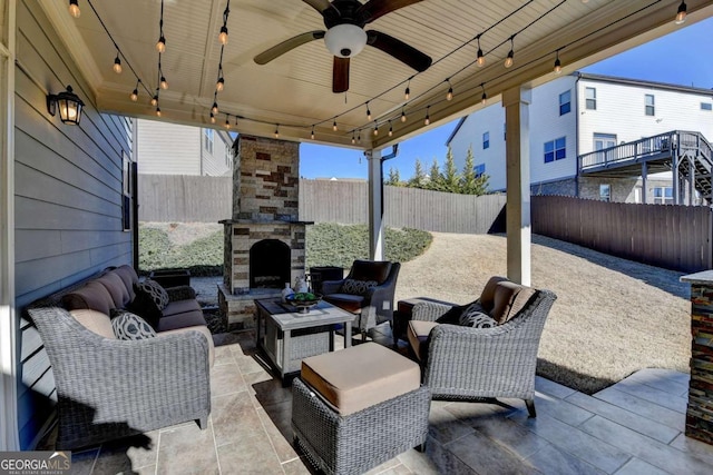 view of patio featuring ceiling fan and an outdoor living space with a fireplace