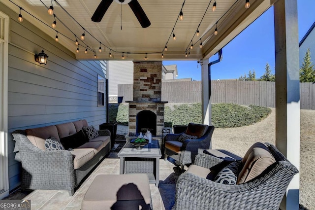 view of patio with an outdoor living space with a fireplace and ceiling fan