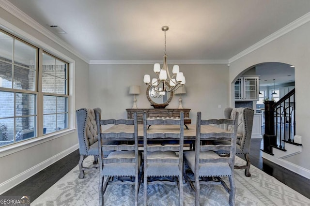 dining space with an inviting chandelier, dark hardwood / wood-style floors, and crown molding