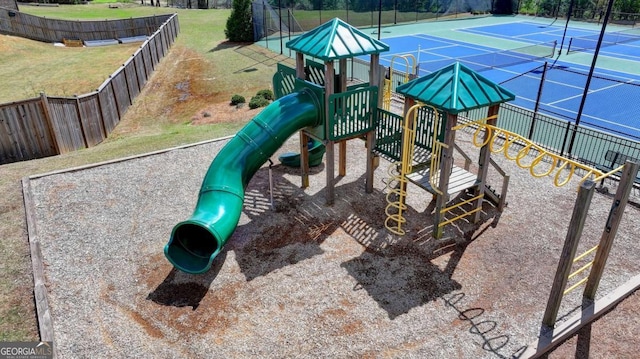 view of play area with tennis court and a yard