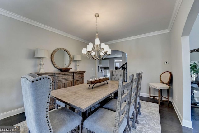 dining space featuring ornamental molding, dark wood-type flooring, and an inviting chandelier