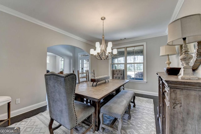 dining room with ornamental molding, dark wood-type flooring, and an inviting chandelier