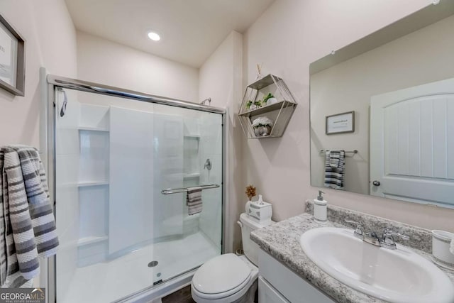 bathroom with toilet, vanity, and an enclosed shower