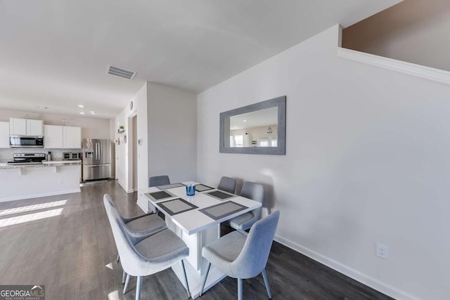 dining area featuring dark wood-type flooring