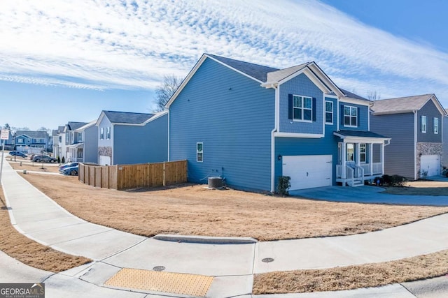 view of front of house with a garage and central AC