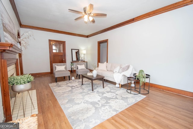 living room featuring ceiling fan, ornamental molding, a fireplace, and hardwood / wood-style floors