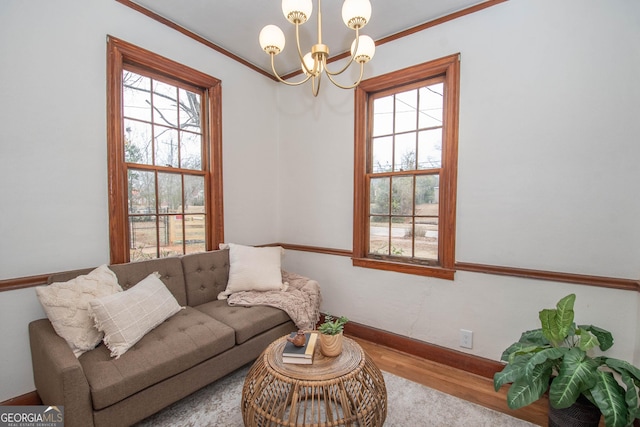 living room featuring a chandelier, ornamental molding, and wood-type flooring