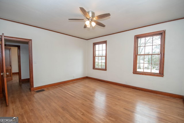 spare room featuring light wood-type flooring, ceiling fan, and crown molding