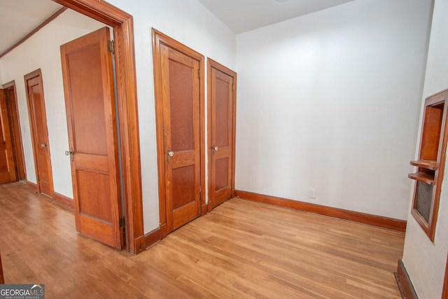 corridor with light hardwood / wood-style floors