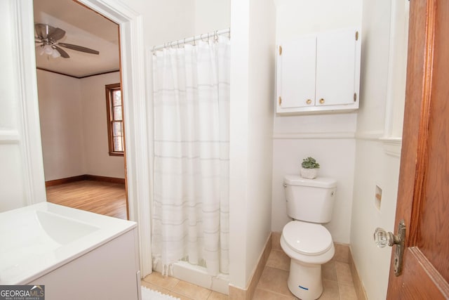 bathroom with tile patterned flooring, ceiling fan, toilet, walk in shower, and vanity