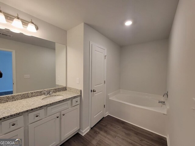 bathroom with vanity, wood-type flooring, and a bathing tub