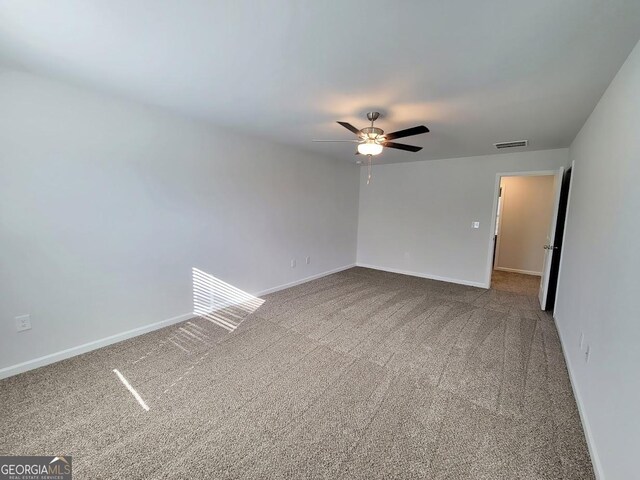 carpeted spare room featuring ceiling fan