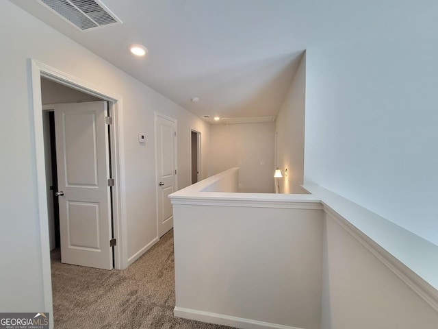 hallway featuring light colored carpet