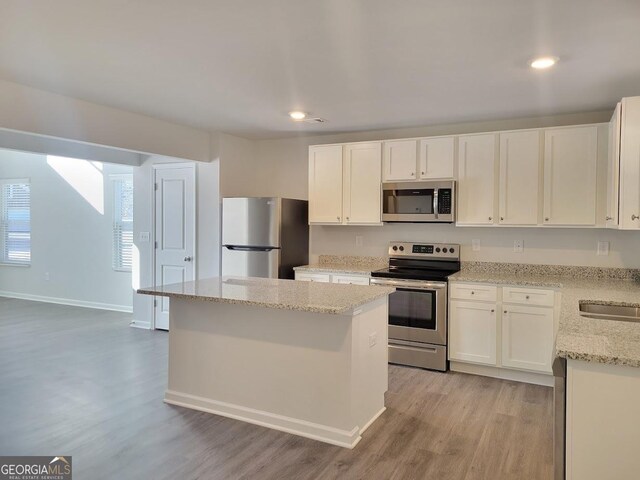 kitchen featuring a kitchen island, white cabinetry, light hardwood / wood-style flooring, and appliances with stainless steel finishes