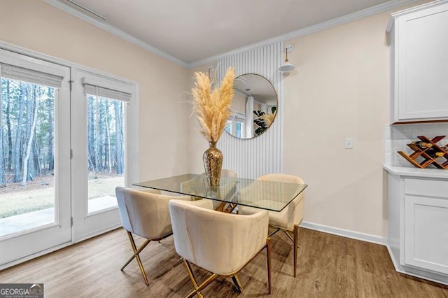 dining room featuring crown molding, light hardwood / wood-style floors, and plenty of natural light