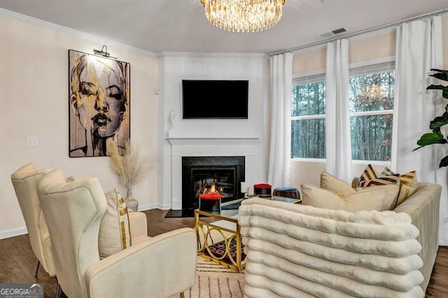 living room with an inviting chandelier, dark hardwood / wood-style floors, and ornamental molding