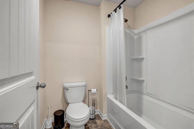 bathroom featuring toilet and shower / bath combination with curtain