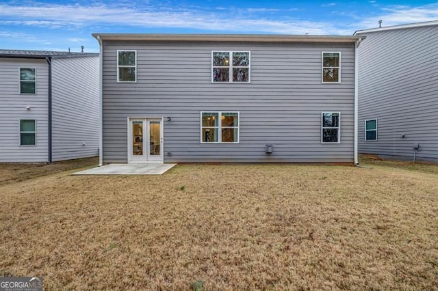 back of house with a lawn and a patio