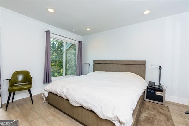 bedroom featuring crown molding and light hardwood / wood-style floors