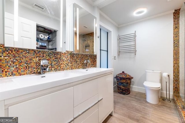 bathroom with crown molding, radiator heating unit, tasteful backsplash, vanity, and wood-type flooring