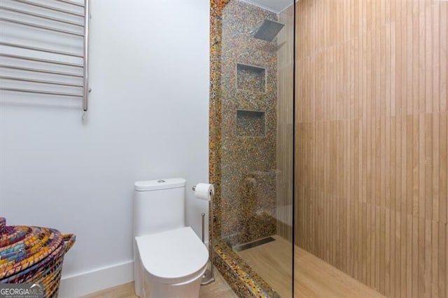 bathroom featuring walk in shower, radiator heating unit, and toilet