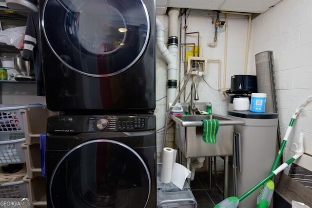 laundry room with stacked washing maching and dryer and sink