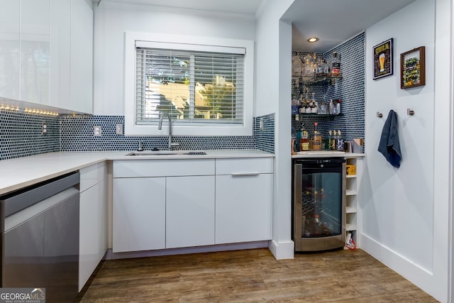 bar with sink, backsplash, wine cooler, white cabinets, and stainless steel dishwasher