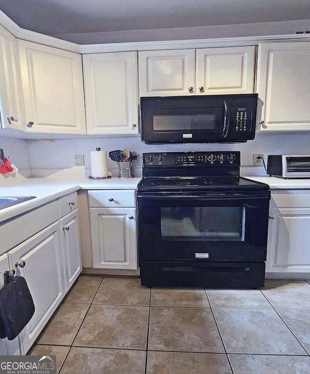 kitchen with black appliances, white cabinetry, and light tile patterned flooring