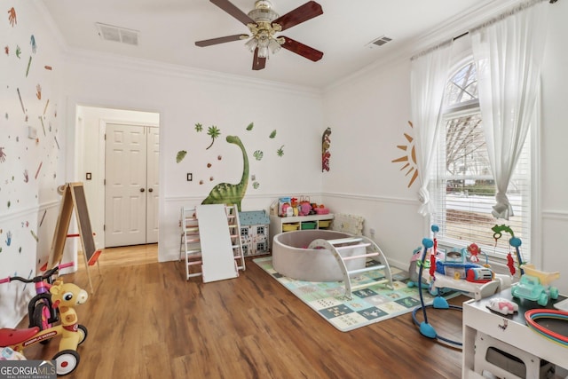 game room featuring hardwood / wood-style flooring, crown molding, and ceiling fan