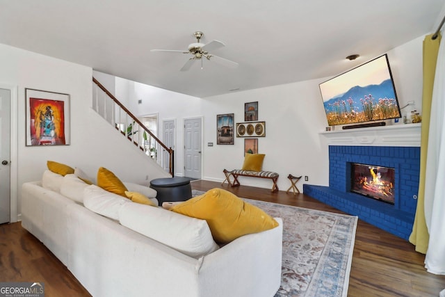 living room with ceiling fan, dark wood-type flooring, and a fireplace