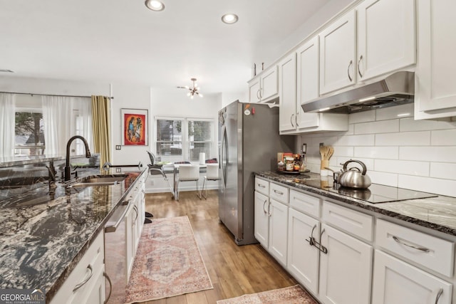 kitchen featuring sink, white cabinetry, stainless steel appliances, and dark stone counters