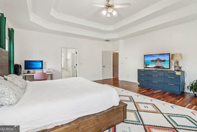 bedroom featuring ceiling fan, dark wood-type flooring, ensuite bathroom, and a tray ceiling