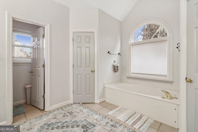 bathroom with a wealth of natural light, lofted ceiling, and tile patterned flooring