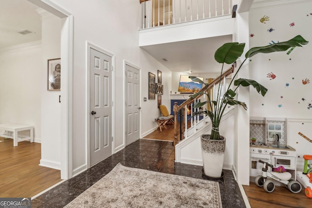 foyer entrance featuring a high ceiling and ornamental molding