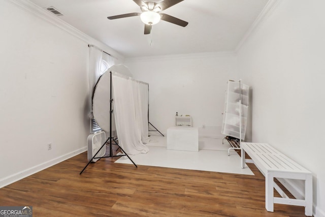 misc room featuring ceiling fan, dark wood-type flooring, and ornamental molding