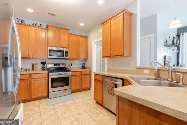 kitchen with stainless steel appliances, hanging light fixtures, and sink