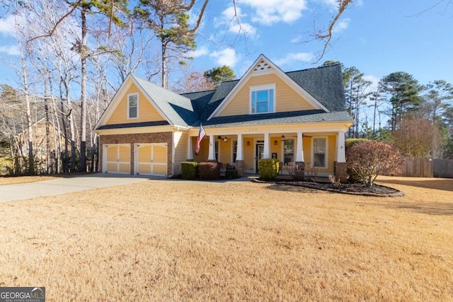 view of front of house with a porch, a garage, and a front lawn