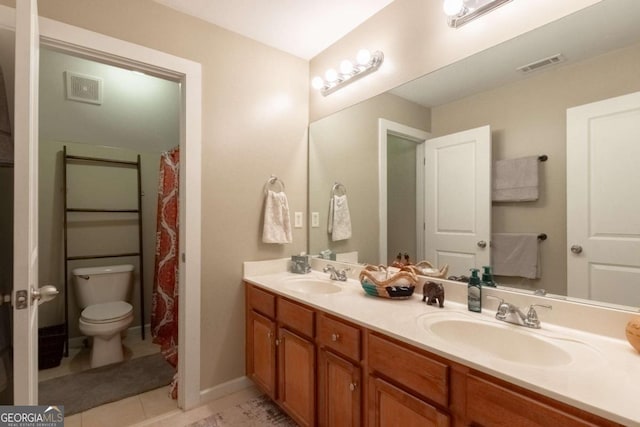 bathroom featuring vanity, tile patterned floors, and toilet