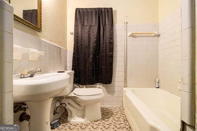 bathroom featuring toilet, separate shower and tub, and tile walls