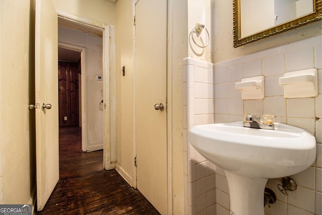 bathroom featuring wood-type flooring and tile walls