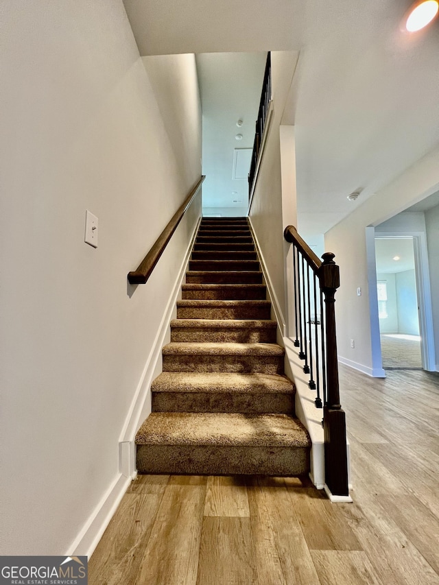 stairway with hardwood / wood-style flooring