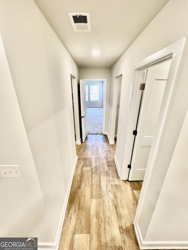 hallway with light hardwood / wood-style floors