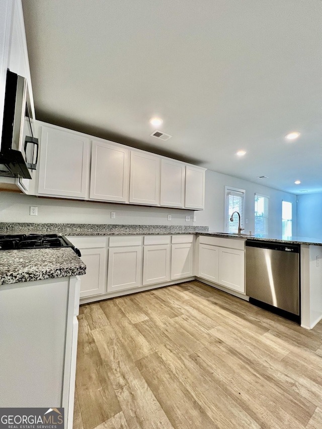 kitchen featuring light stone countertops, dishwasher, white cabinetry, sink, and light hardwood / wood-style flooring