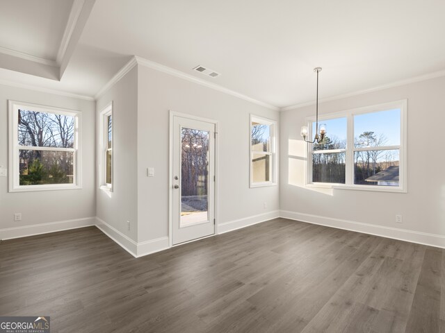 unfurnished dining area featuring ornamental molding, plenty of natural light, dark hardwood / wood-style floors, and an inviting chandelier