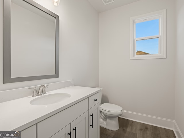 bathroom featuring vanity, toilet, and hardwood / wood-style floors
