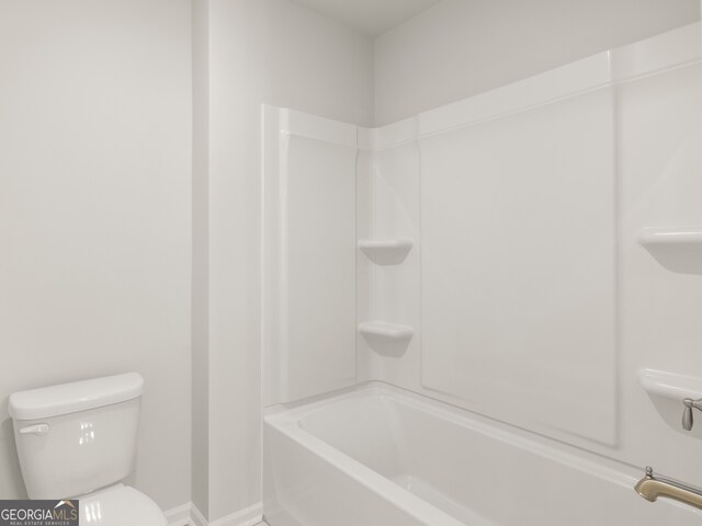 bathroom featuring bathtub / shower combination and toilet