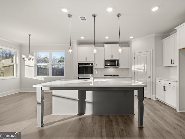 kitchen featuring pendant lighting, a breakfast bar, white cabinets, and appliances with stainless steel finishes