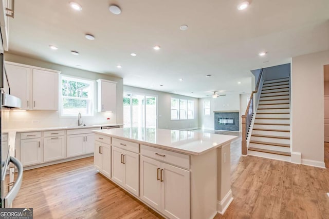 kitchen featuring sink, a center island, decorative backsplash, and white cabinetry