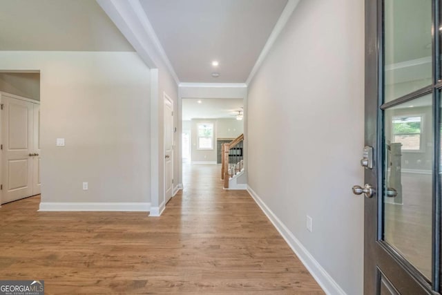 corridor with crown molding and light wood-type flooring